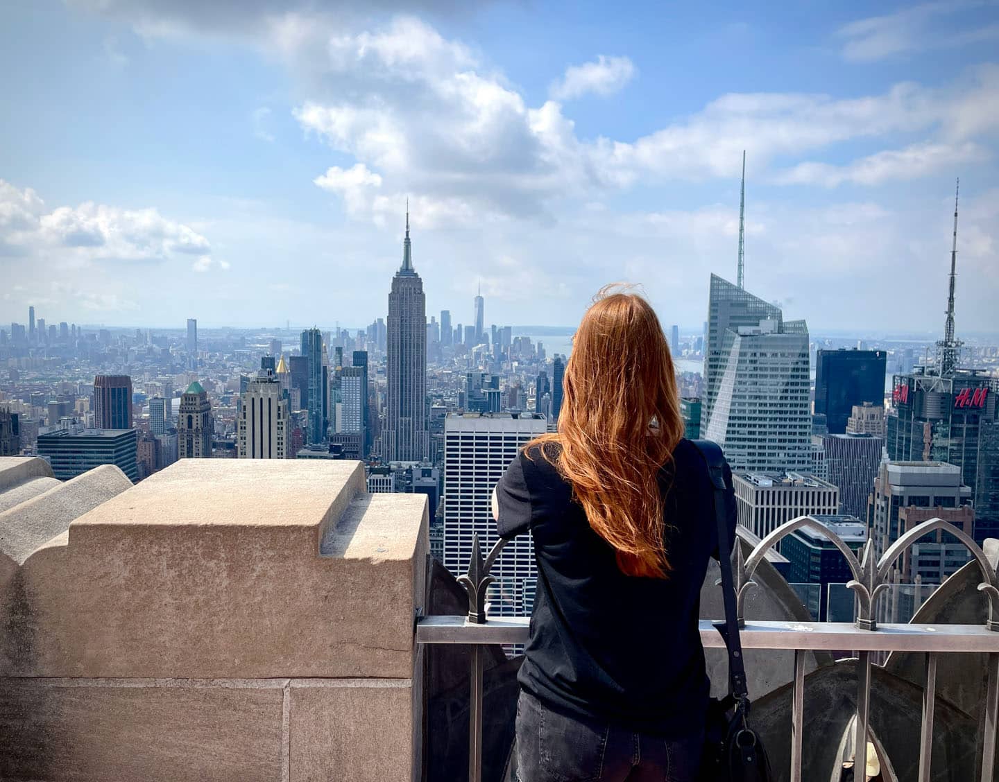 woman leaning out overlooking new york skyline and empire state building