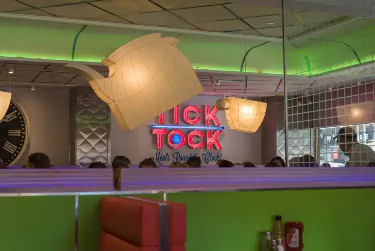 tick tock diner neon sign over booth with funky lampshades and large mirror