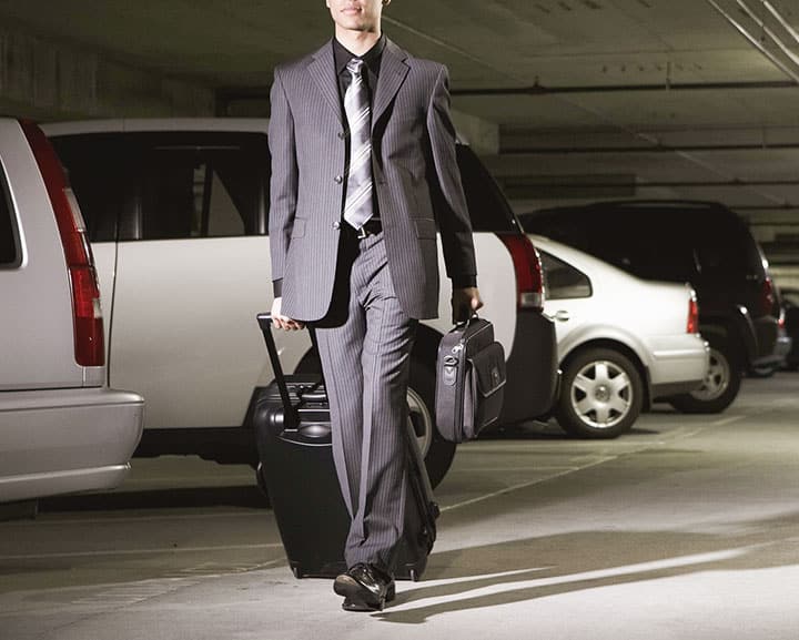 man traveling for business with case and luggage