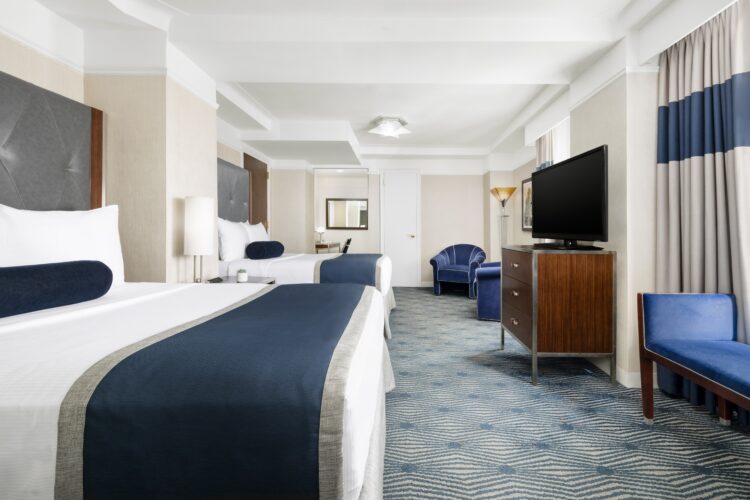 executive double suite room in nyc with two large double beds facing television set and two double windows