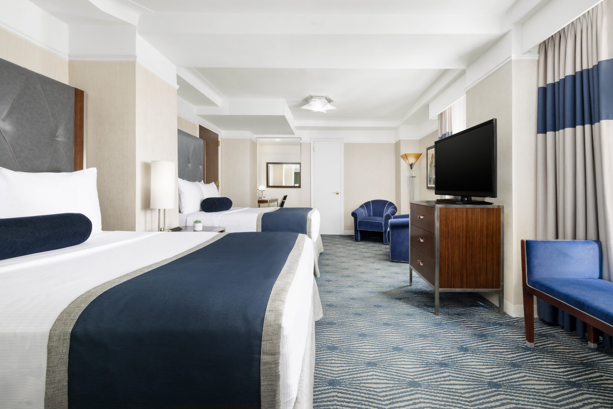 executive double suite room in nyc with two large double beds facing television set and two double windows
