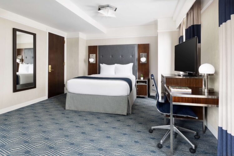 executive queen suite with large queen bed and spacious room with desk seating area and large double mirror