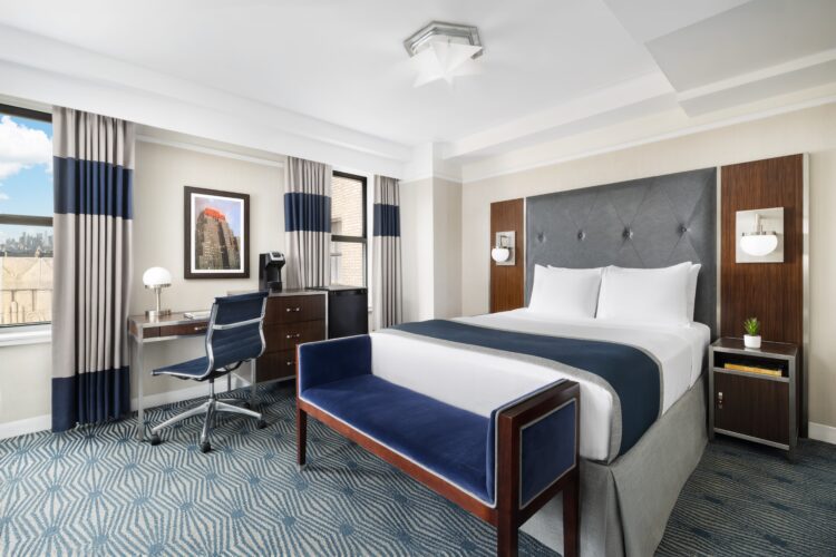 exec queen suite at the new yorker midtown nyc with large queen bed, desk seating area and large window