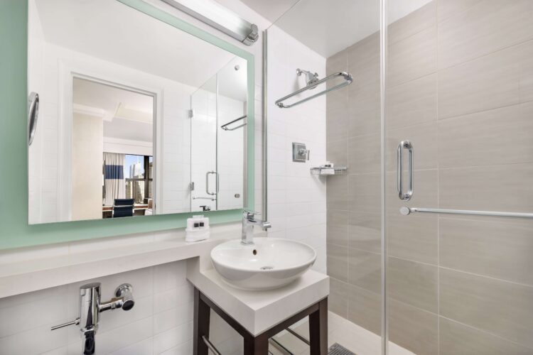 executive shower room with large vanity mirror, large double door shower and sink wash basin