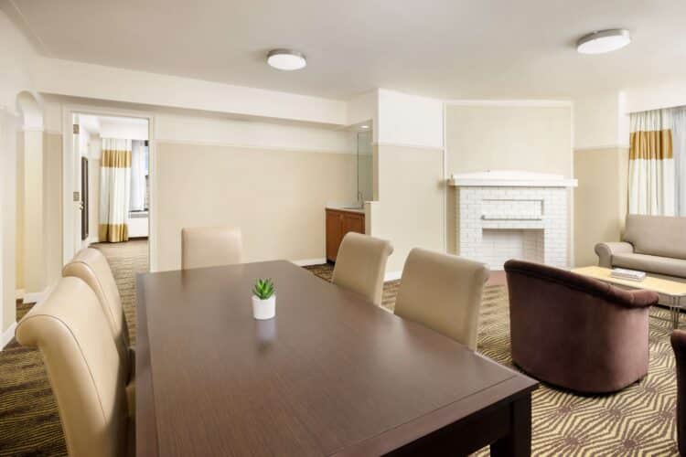 Open-plan suite dining area with large table and adjoining living space