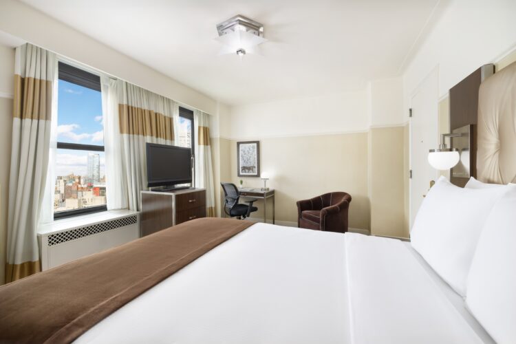 hotel queen suite at the new yorker with large open double windows with full nyc view