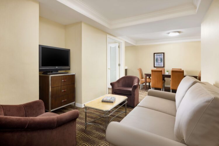 Comfortable suite living area with sofa, armchairs, TV, and coffee table