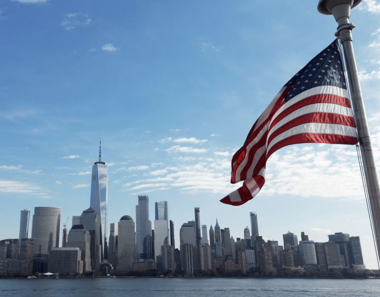 american flag over new york skyline in bright summer day 