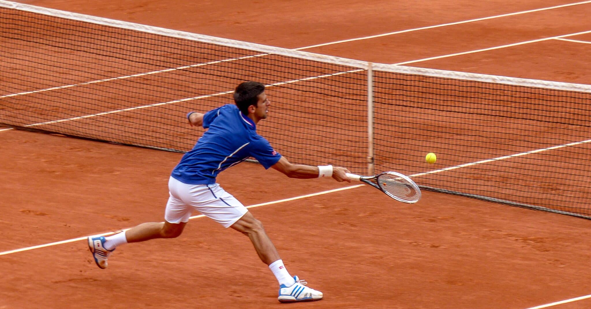 US tennis open - man serving tennis ball on orange pitch