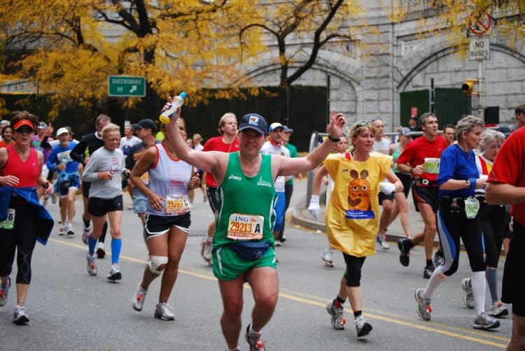 nyc marathon people running across the finish line celebrating
