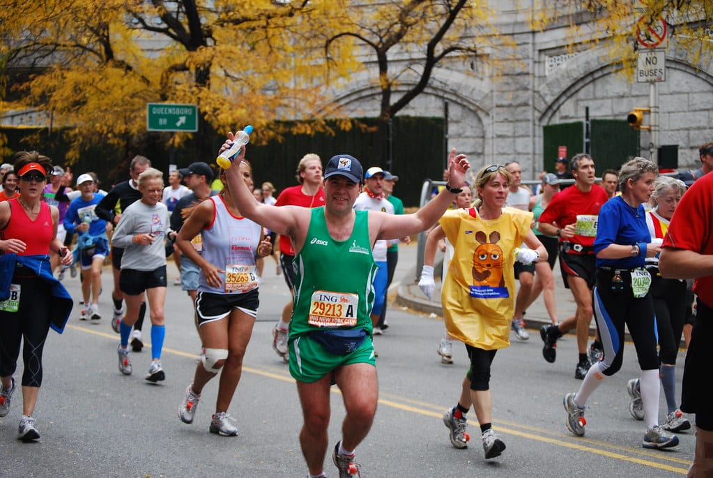 nyc marathon people running across the finish line celebrating